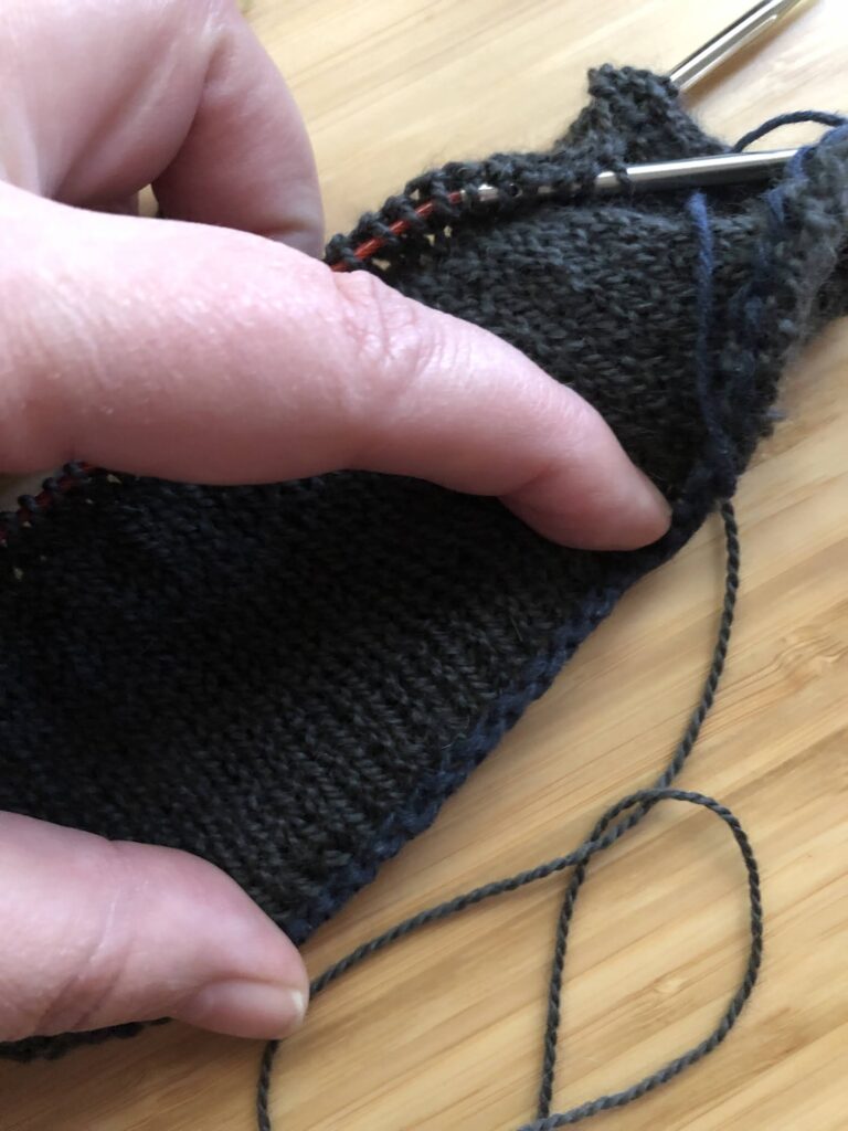 Photo showing a detail of the cotton yarn Amy used to cast on stitches for knitting sleeves separately from the body.